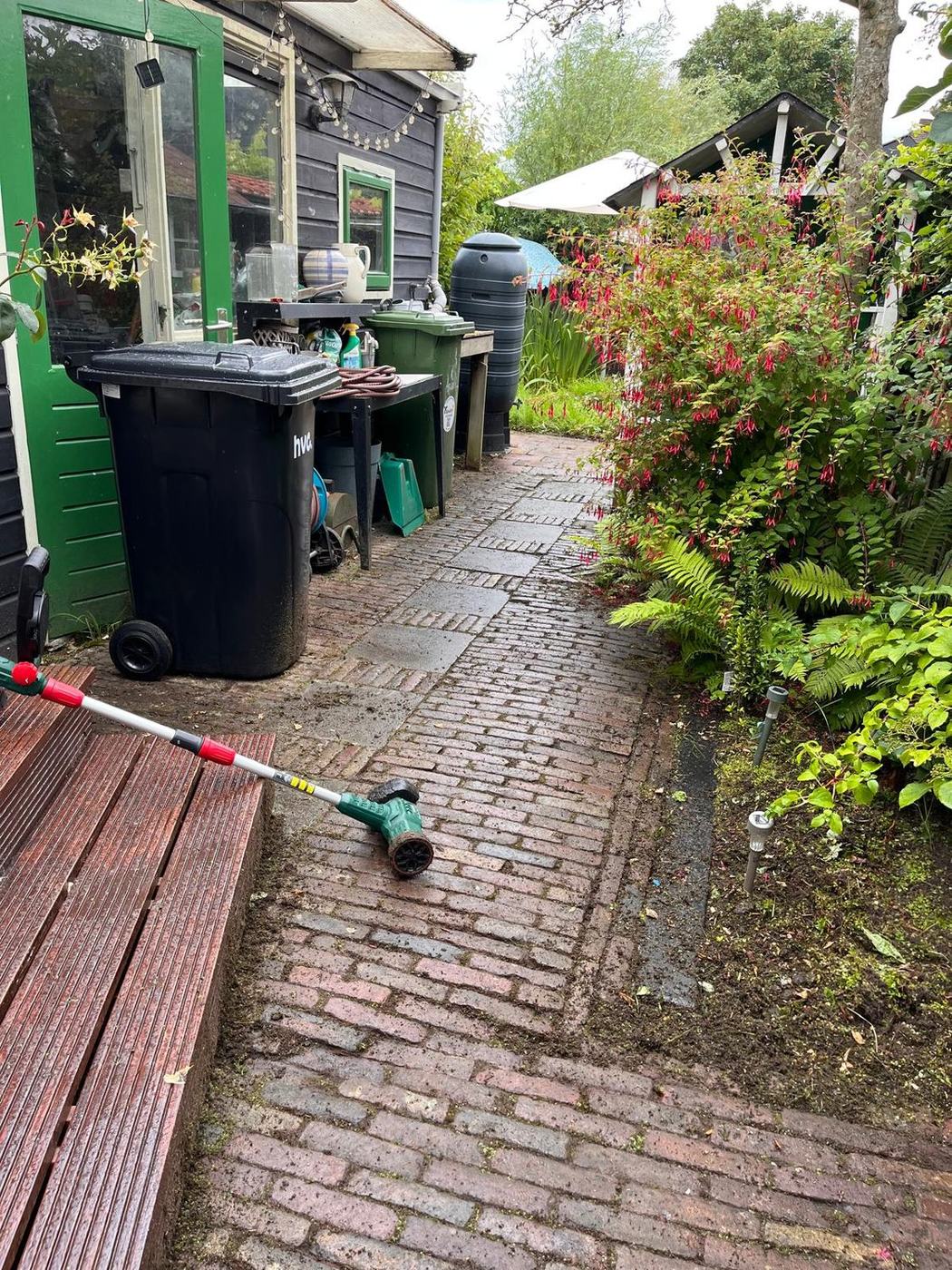 Hetzelfde klinkerpad na het wieden: de voegen zijn schoon en de stenen weer zichtbaar