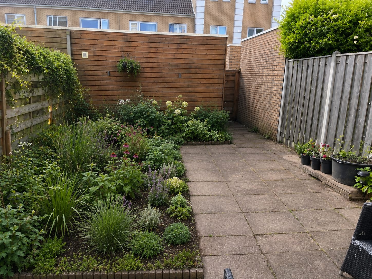 Vergroende tuin met borders vol vaste planten langs een tuinpad